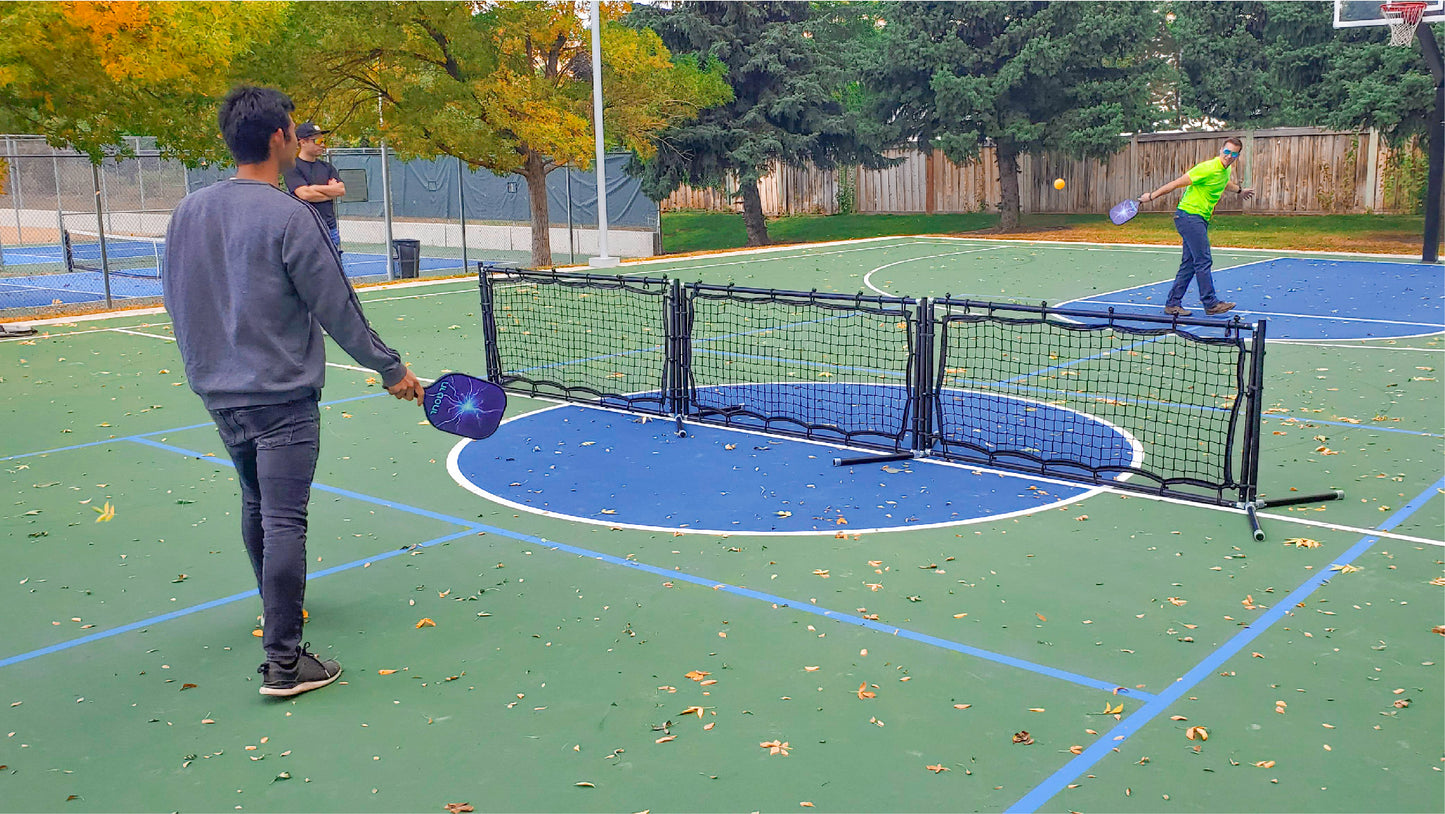 Two guys playing pickleball on a basketball court